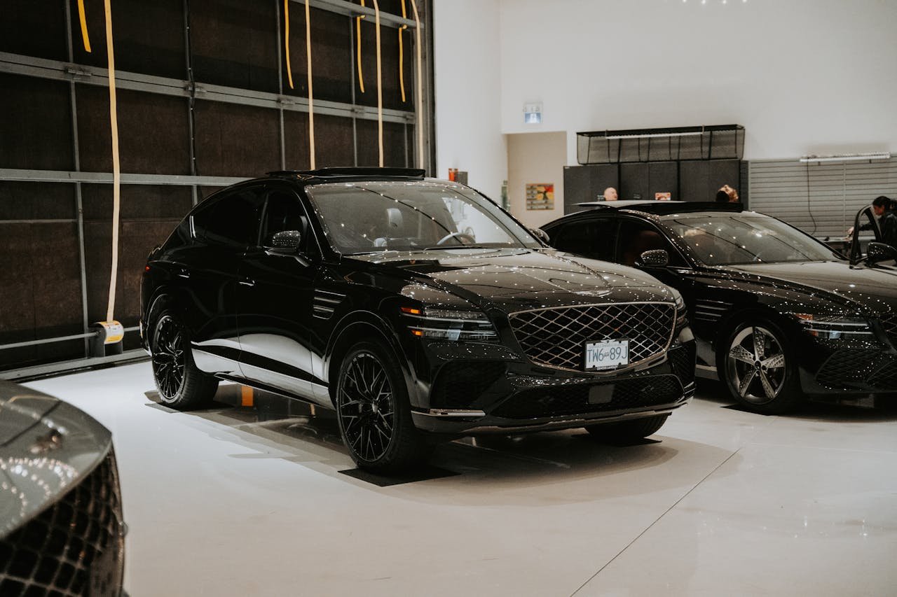 get-in-touch Luxury black SUVs displayed in an indoor car showroom with elegant lighting.